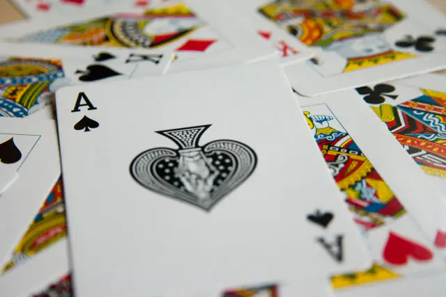Ace of spades lying on top of a spread of playing cards