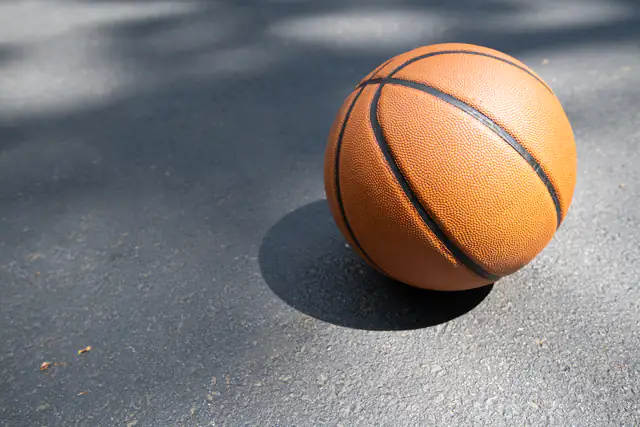 Basketball resting on an asphalt court