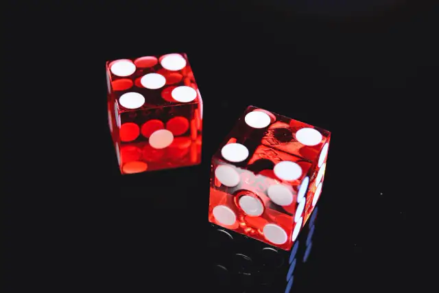 Two translucent red casino dice on a dark background