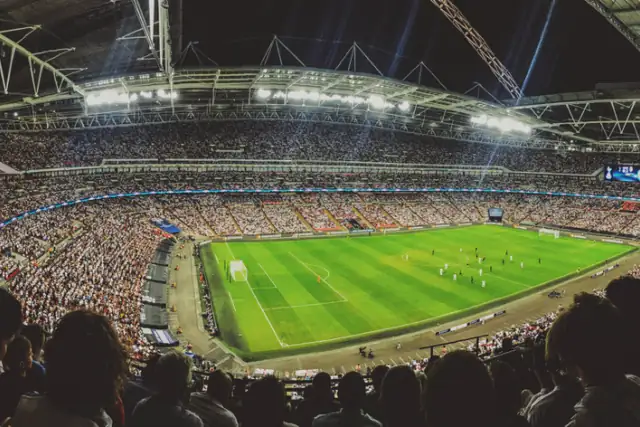Packed football stadium under floodlights during a match